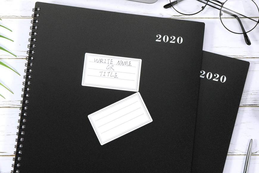 black 2020 planner on a white table next to laptop and glasses