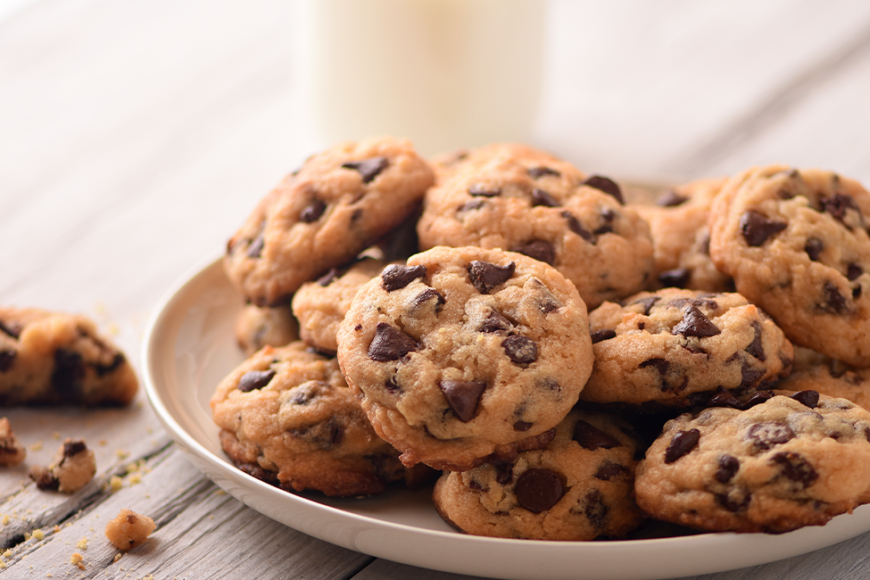 plate of chocolate chip cookies with a glass of milk