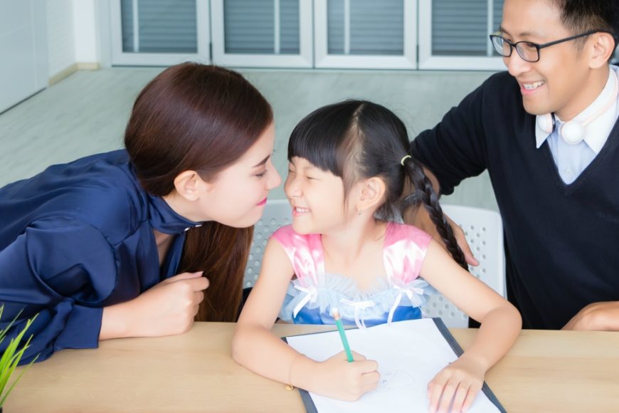 family at a table helping child with homework